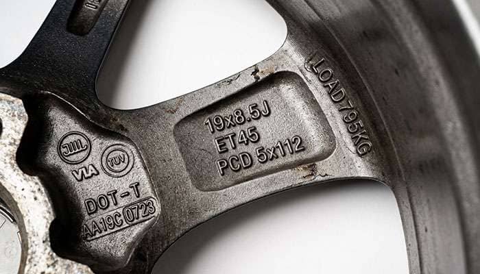 Close-up of load rating and certification stampings cast into the reverse side of an alloy wheel