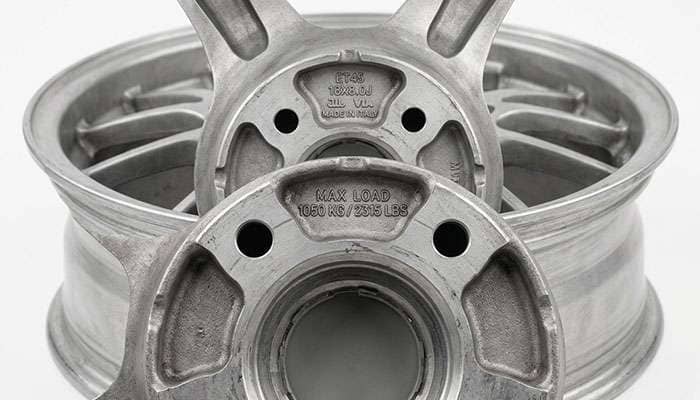 Close-up of the back of an aluminum wheel showing the stamped maximum load rating