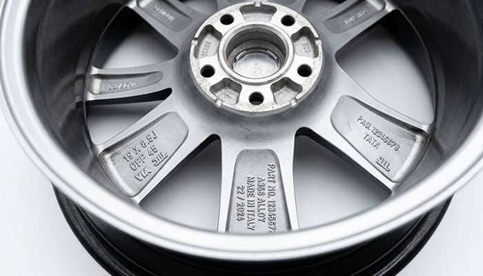 Back side of an alloy wheel showing the cast part number, size, and offset stamps