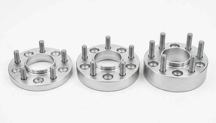 Three hub-centric wheel spacers in 1-inch, 1.5-inch, and 2-inch thicknesses side by side