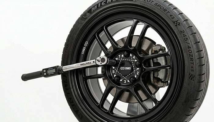 Tightening lug nuts in a star pattern with a torque wrench on a newly installed wheel