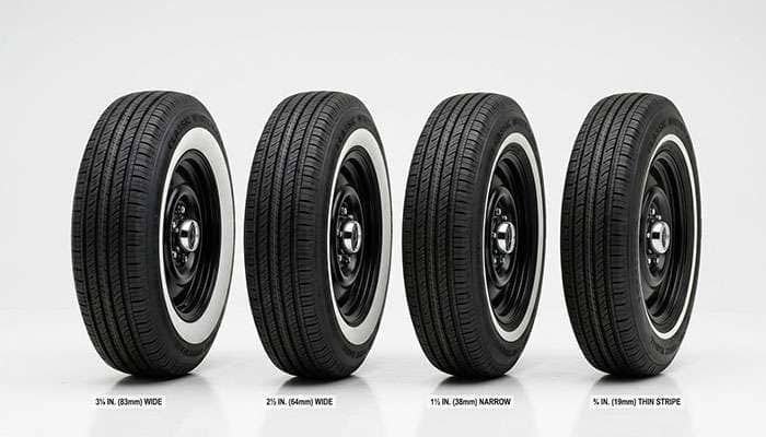 Four whitewall tires standing upright showing different whitewall widths from wide 3-inch to narrow pinstripe on a clean white studio surface