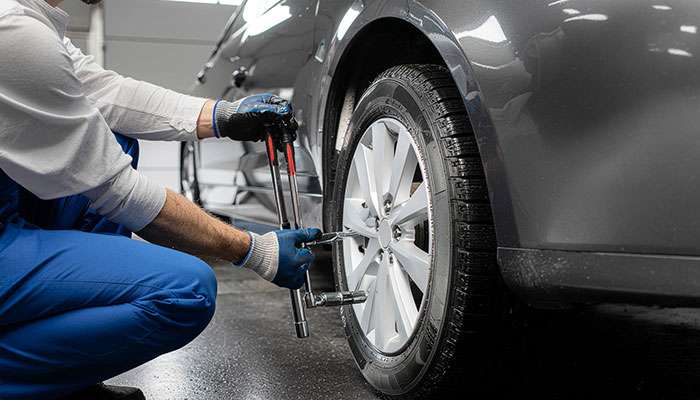 Tech performing wheel alignment