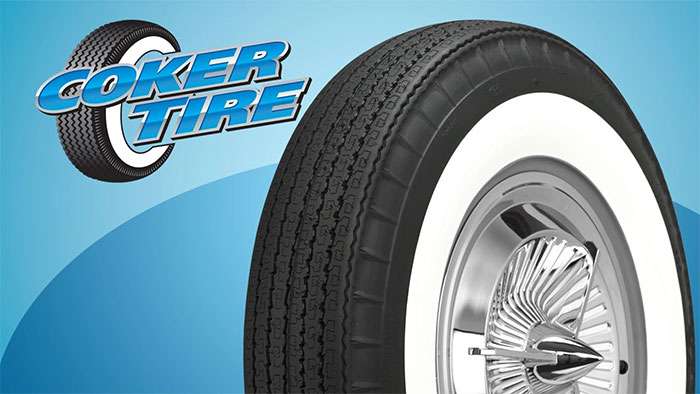 Close-up of an American Classic bias look wide whitewall radial tire with a chrome spiked hubcap on a blue background.