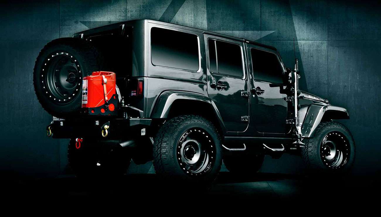 Close-up of rugged Americus off-road tires on a vehicle driving over rocky desert terrain at sunset