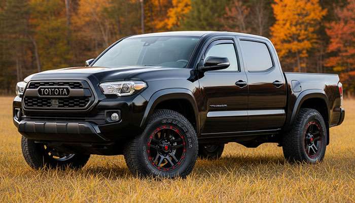 Black Toyota Tacoma truck with black and red off-road wheels showcasing durability and rugged performance capability