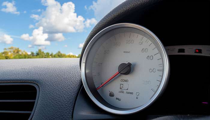 Close-up of a car temperature gage needle pointing to the cold side on the dashboard display