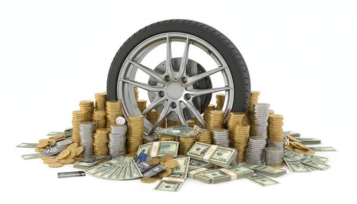 Car wheel surrounded by stacks of coins and dollar bills representing savings and payment alternatives