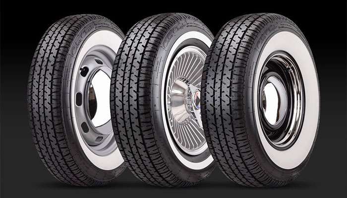 Three Coker Classic Star Series whitewall radial tires with different vintage wheel styles on a black background