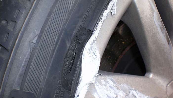 Curb rash scuffs and gouges along a wheel’s outer edge.