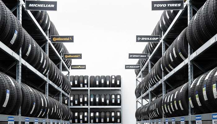 Extensive variety of tire brands and models displayed in organized warehouse setting