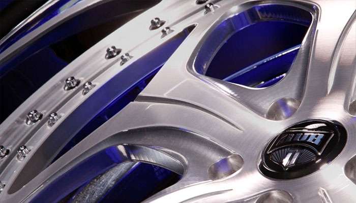 Close-up detail of polished DUB 2-Piece Series custom wheel showing precision bolts and blue accent details