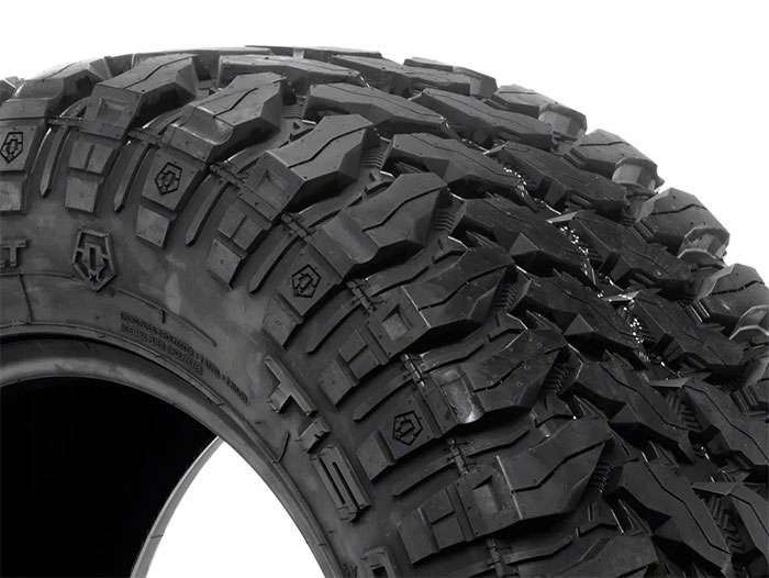 Extreme mud-terrain tire with massive lugs and high void ratio for maximum off-road traction