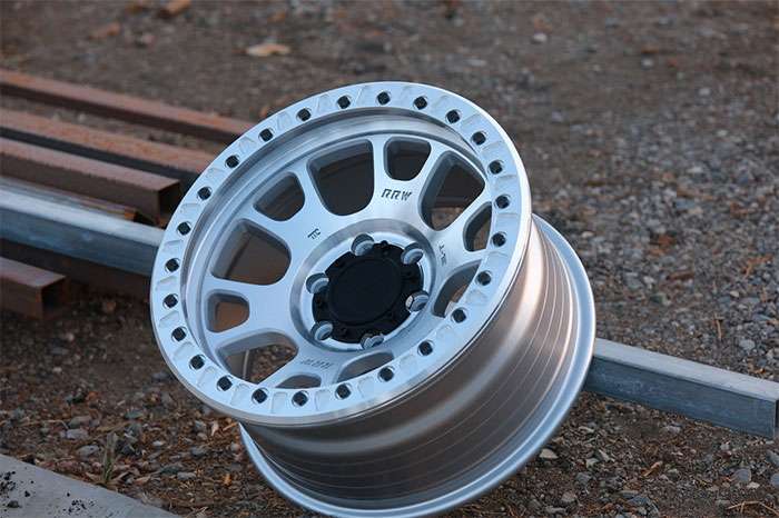 Flow form off-road wheel with thin spokes mounted on SUV on dirt road