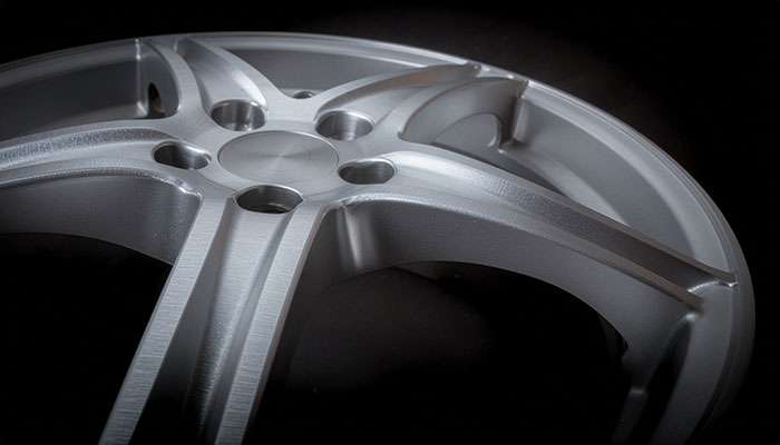 Forged alloy wheel with deep concave spokes and brushed finish.