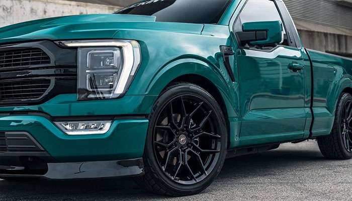 Close-up of a teal street truck featuring black monoblock flowformed Forgestar rims and SUV-style wheels