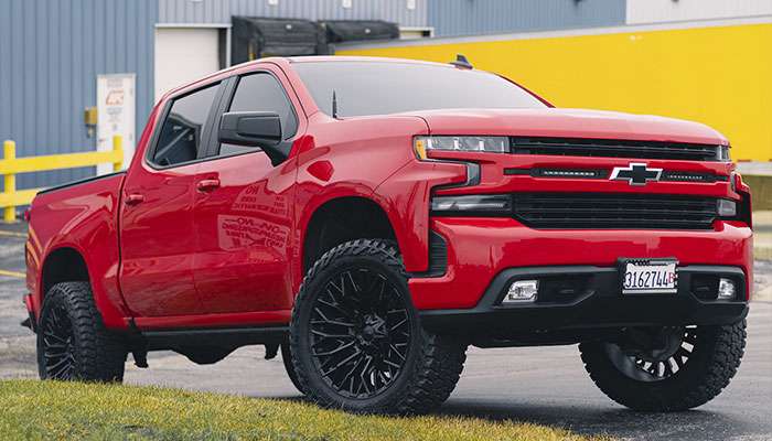 Fuel Wheels Silverado 2500 Rincon Gloss Black Milled 8-Lug off-road tire mounted on red truck