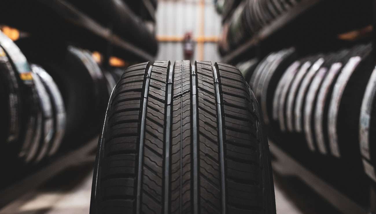 Close-up of GT Radial tires neatly lined up in a well-lit factory aisle showcasing quality and design