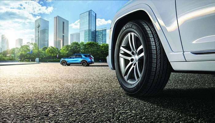 Laufenn X FIT HP tire mounted on white car with city skyline background showcasing urban performance