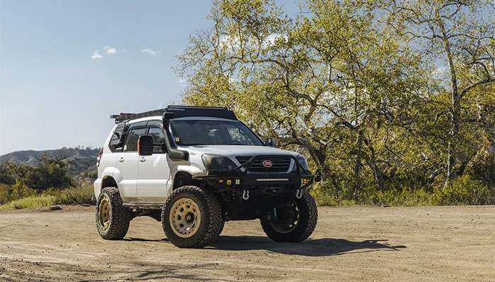 White 2007 Lexus GX470 off-road SUV with bronze XD Storm wheels on dirt trail