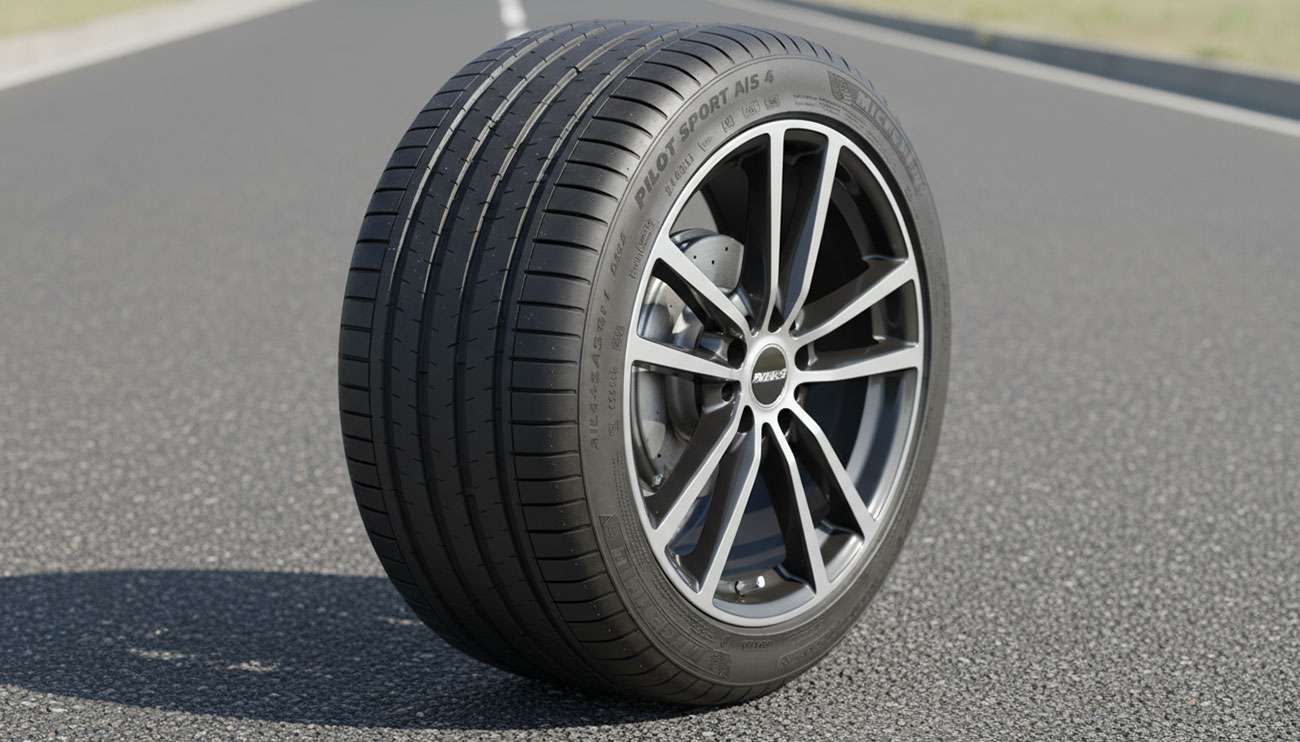 Close-up of a new, high-performance tire mounted on a modern car wheel in sunlight on asphalt road