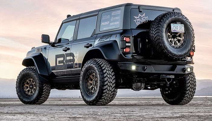 Black off-road SUV with Mayhem 8306 Ridgeline bronze wheels on rugged terrain showing aggressive stance