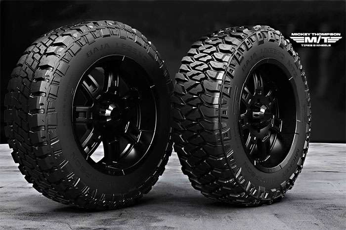 Two black Mickey Thompson Baja Legend EXP off-road truck tires on concrete floor