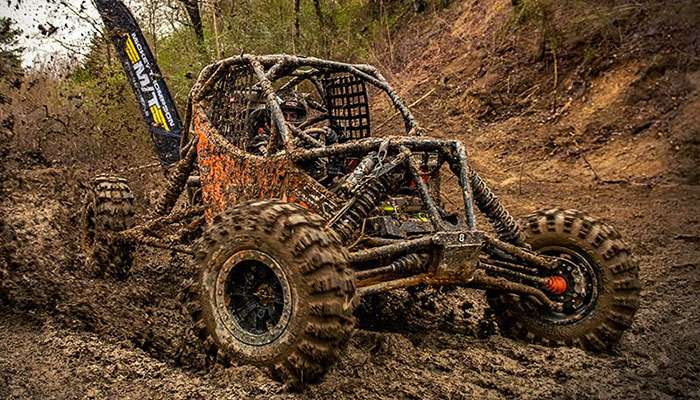 Close-up of a muddy Mickey Thompson Baja Pro tire during a muck test on a wet off-road trail