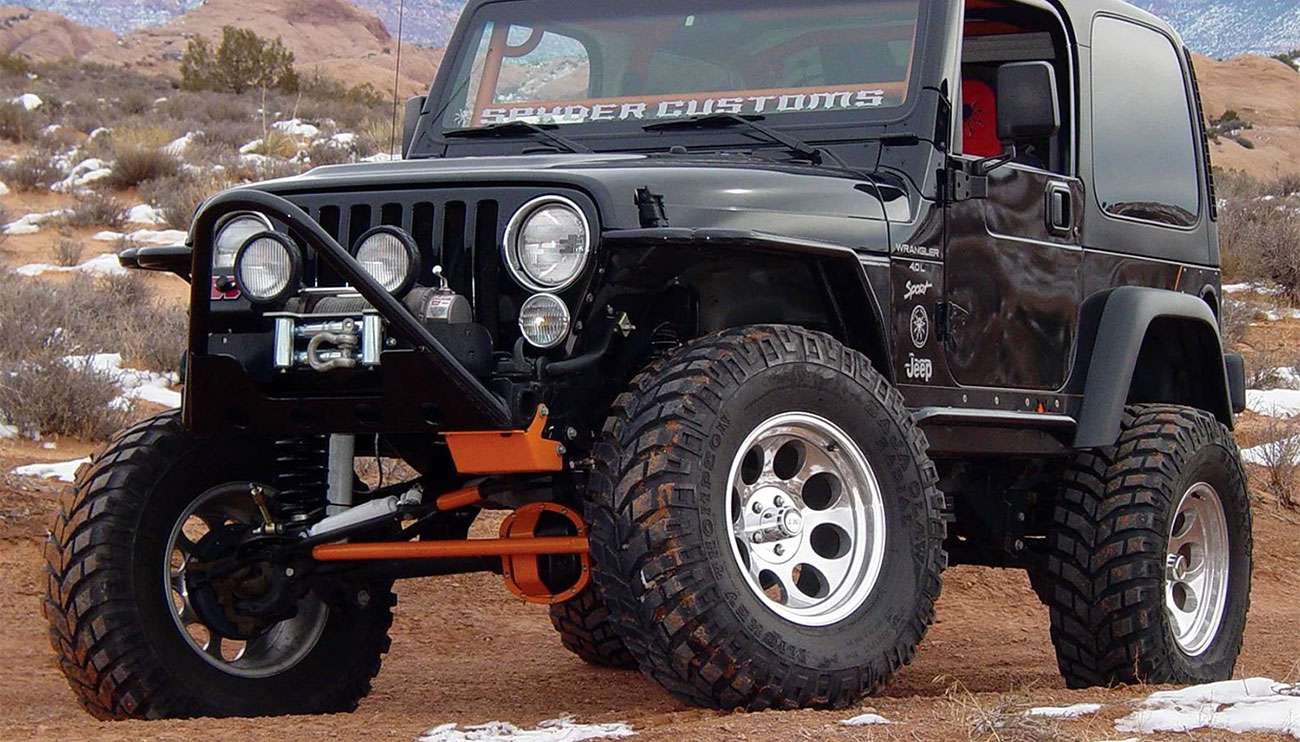 Rugged Mickey Thompson wheel and tire mounted on off-road truck in desert terrain at sunset