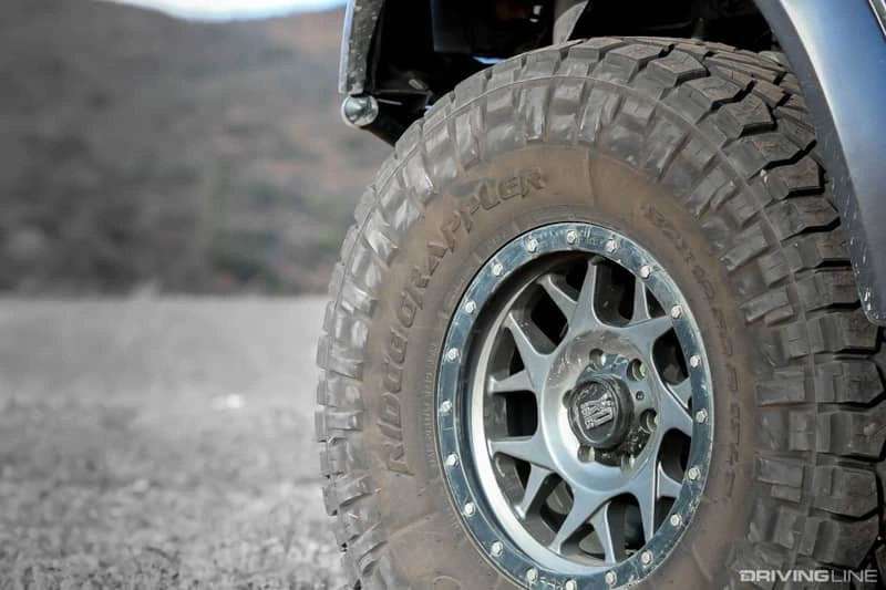 Close-up of a rugged off-road tire on a vehicle, ready for summer adventure and tough terrain.