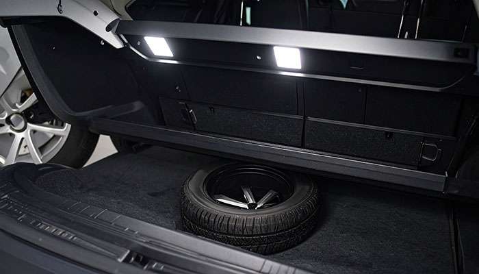 Compact spare donut tire in vehicle trunk