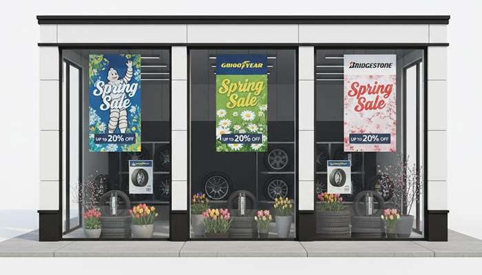 Automotive tire retailer displaying spring promotional signage with discount offers on major tire brands