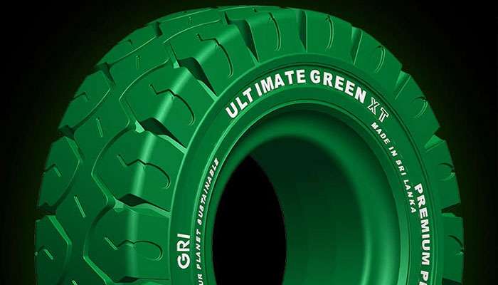 Green GRI Ultimate Green XT sustainable solid tire with deep treads, made in Sri Lanka, displayed on a black background.