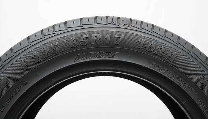 Tire sidewall showing detailed markings including size, load index, speed rating, and manufacturing information