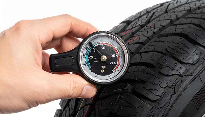 Close-up view of tire tread depth gauge measuring remaining tread to determine replacement timing