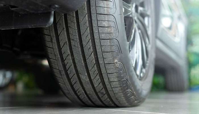 Close-up of a car tire showing tread patterns and wear, highlighting the effects of driving habits on tire condition.