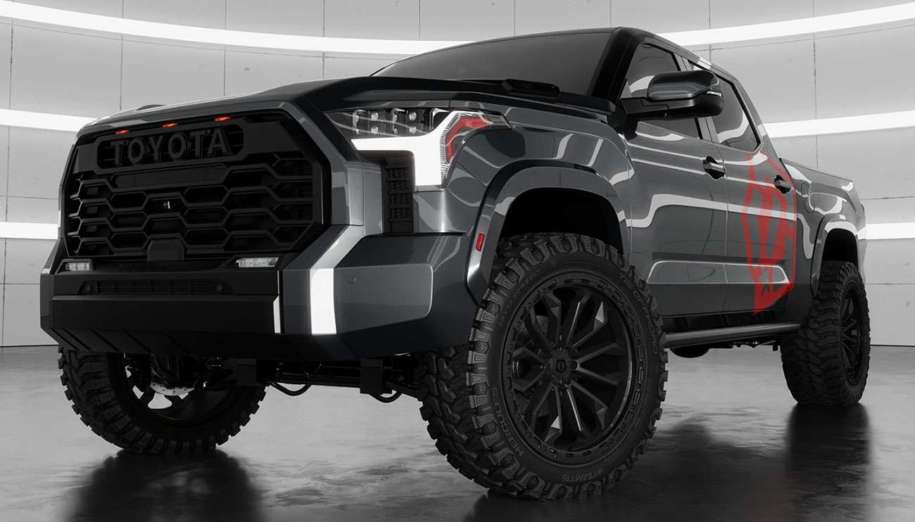 Black Toyota pickup truck with rugged TIS wheels displayed in modern showroom with wheel samples on walls