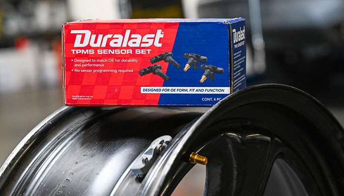 Technician replacing a TPMS sensor and reviewing replacement cost details