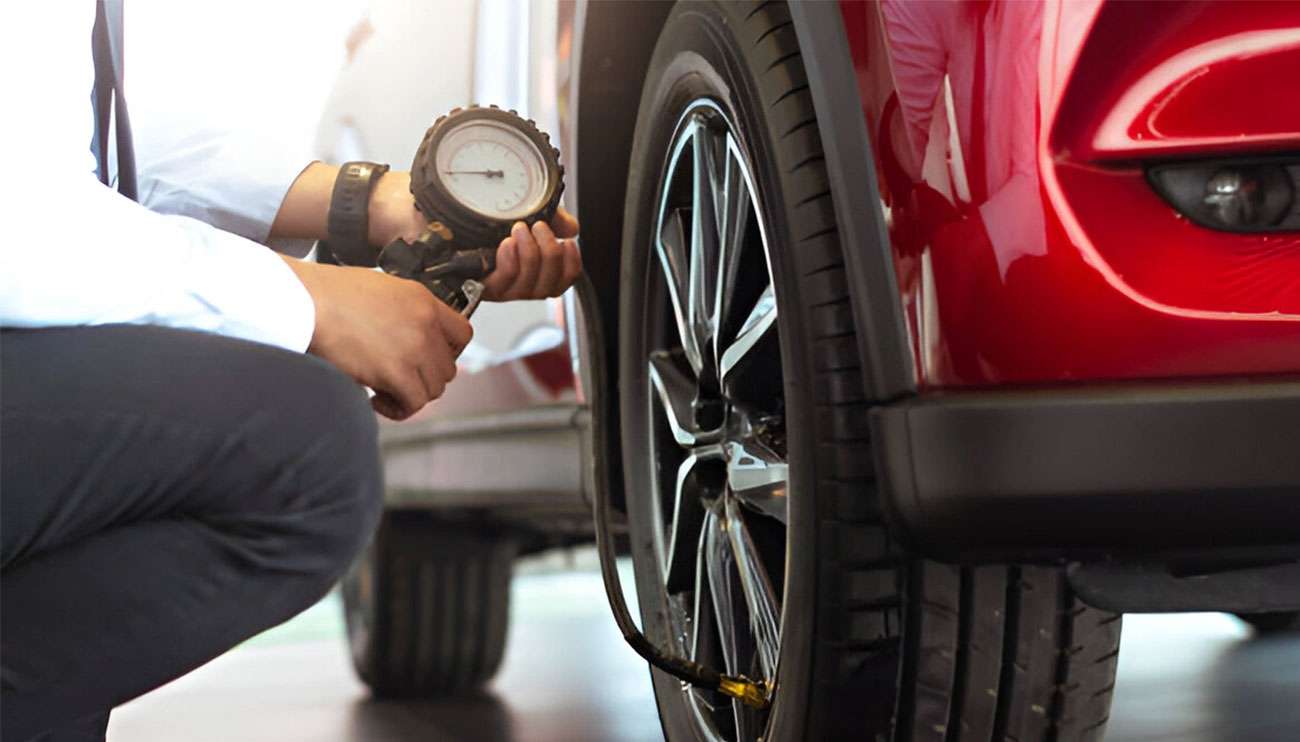 Man checking tire pressure through tpms sensor in garage.
