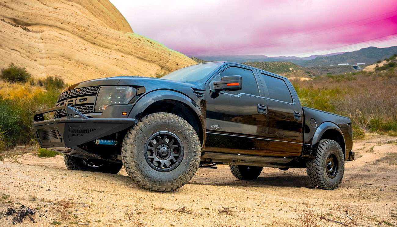 Black Ford pickup truck with polished Ultra brand rims showcased in a studio with bright lighting