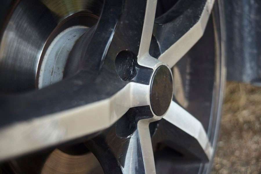 Close-up of a car wheel showcasing the difference between OEM and aftermarket wheel designs.