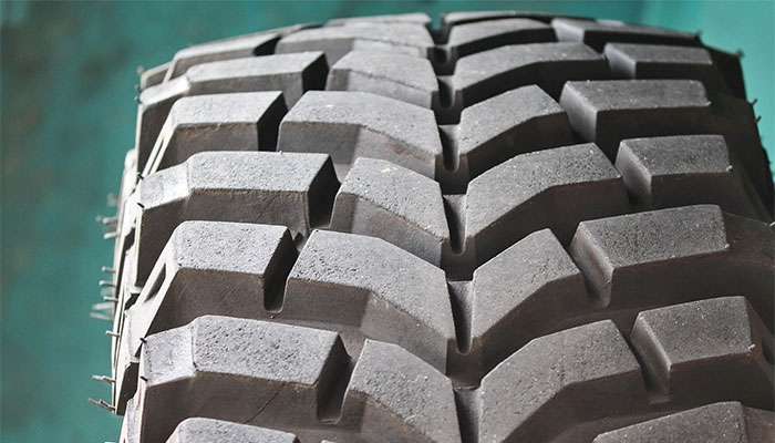 Close-up of deep tread pattern on an all-terrain off-road vehicle tire for enhanced grip and durability.