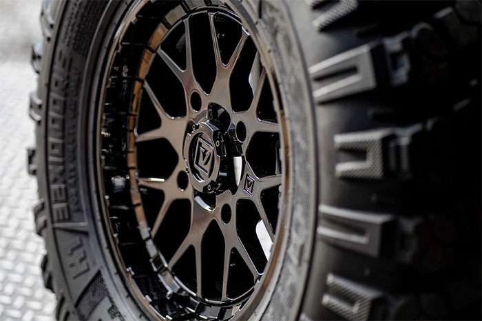 Close-up of a black Valor Offroad UTV wheel with detailed spokes and rugged tire tread.
