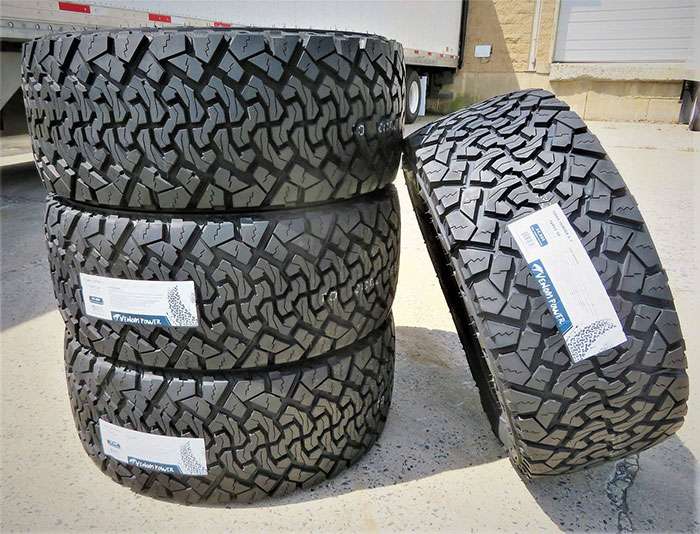 Set of four 245/60R18 Venom Power Terra Hunter X/T all-terrain tires stacked outdoors on pavement