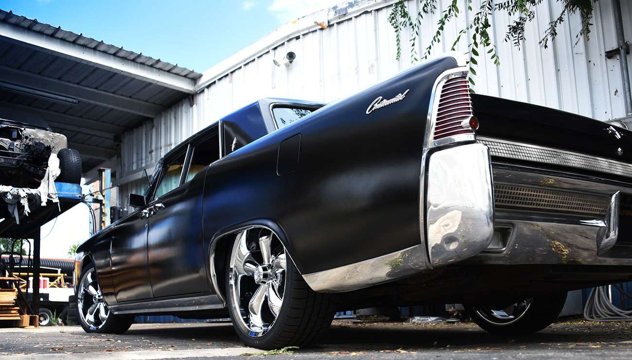 Black Ford F-150 pickup truck with large shiny Vision rims in a studio setting under bright lights