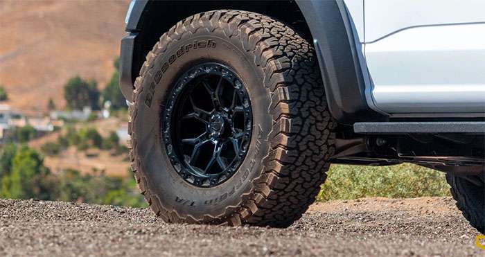Close-up of a black Vorsteiner Offroad performance truck wheel with BFGoodrich all-terrain tire on a white truck