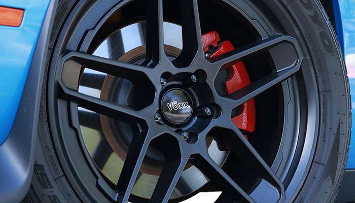 Close-up of a blue sports car showcasing Voxx Wheels