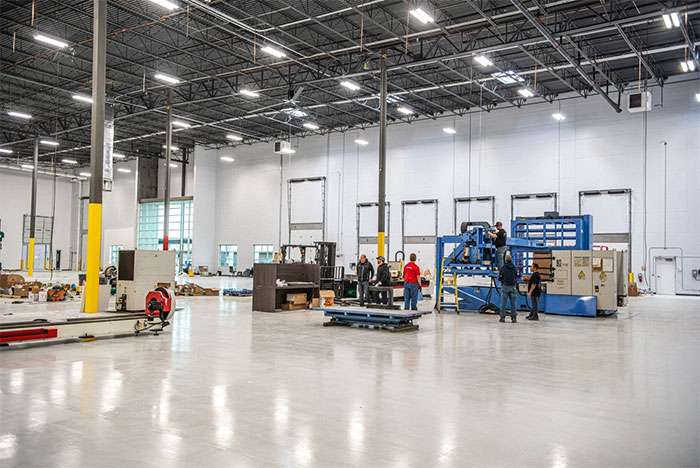 Industrial manufacturing facility with workers assembling wheels at Wheel Pros