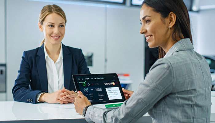 Customer approved for tire financing on a digital tablet at a wheel shop counter.